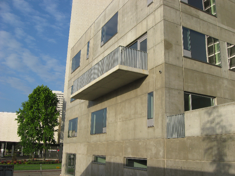 Galvanized balcony railing and window screens on a concrete building