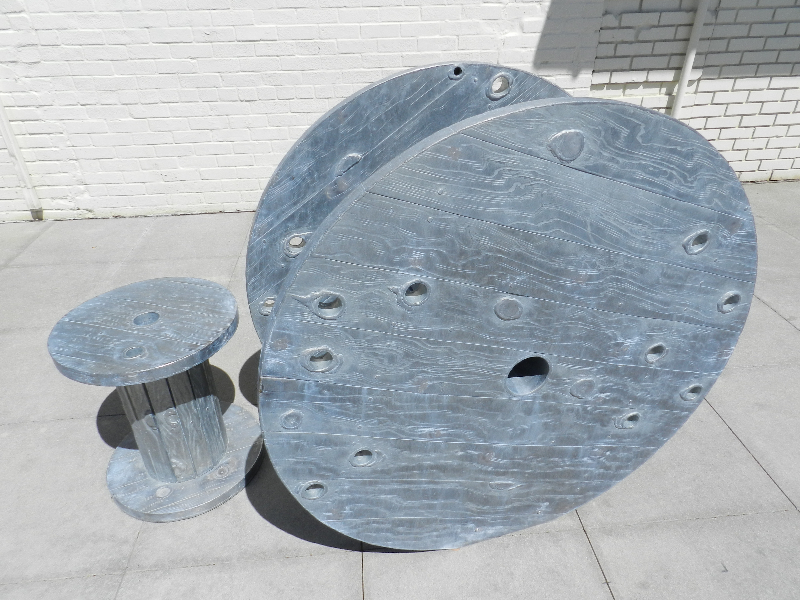 Freshly galvanized steel discs and a spool showing the spangled zinc surface